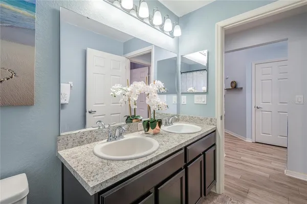 a bathroom with a granite countertop sink a toilet and a mirror