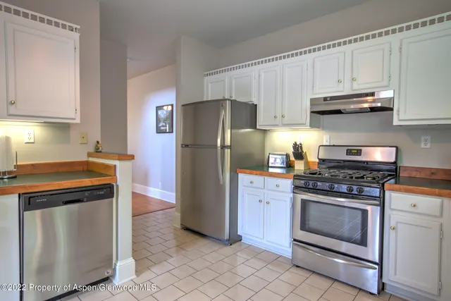 a kitchen with cabinets stainless steel appliances and a counter space