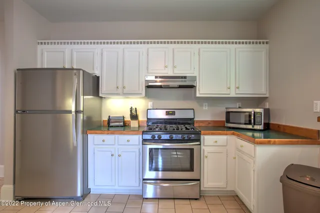 a kitchen with cabinets stainless steel appliances and a counter space