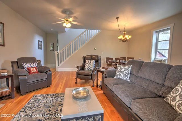 a living room with furniture and a chandelier