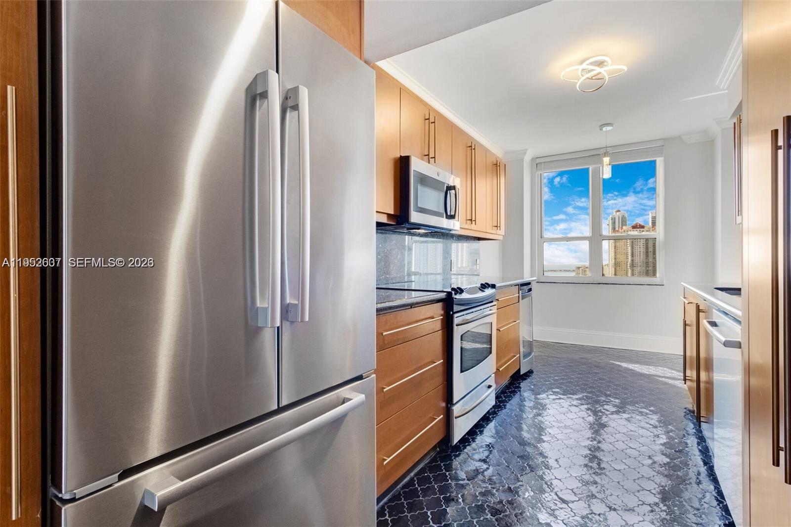 701 Brickell Key Boulevard, Unit 2103 Miami, FL 33131 - Photo 7 of 38 ss appliances - galley kitchen with space for breakfast table