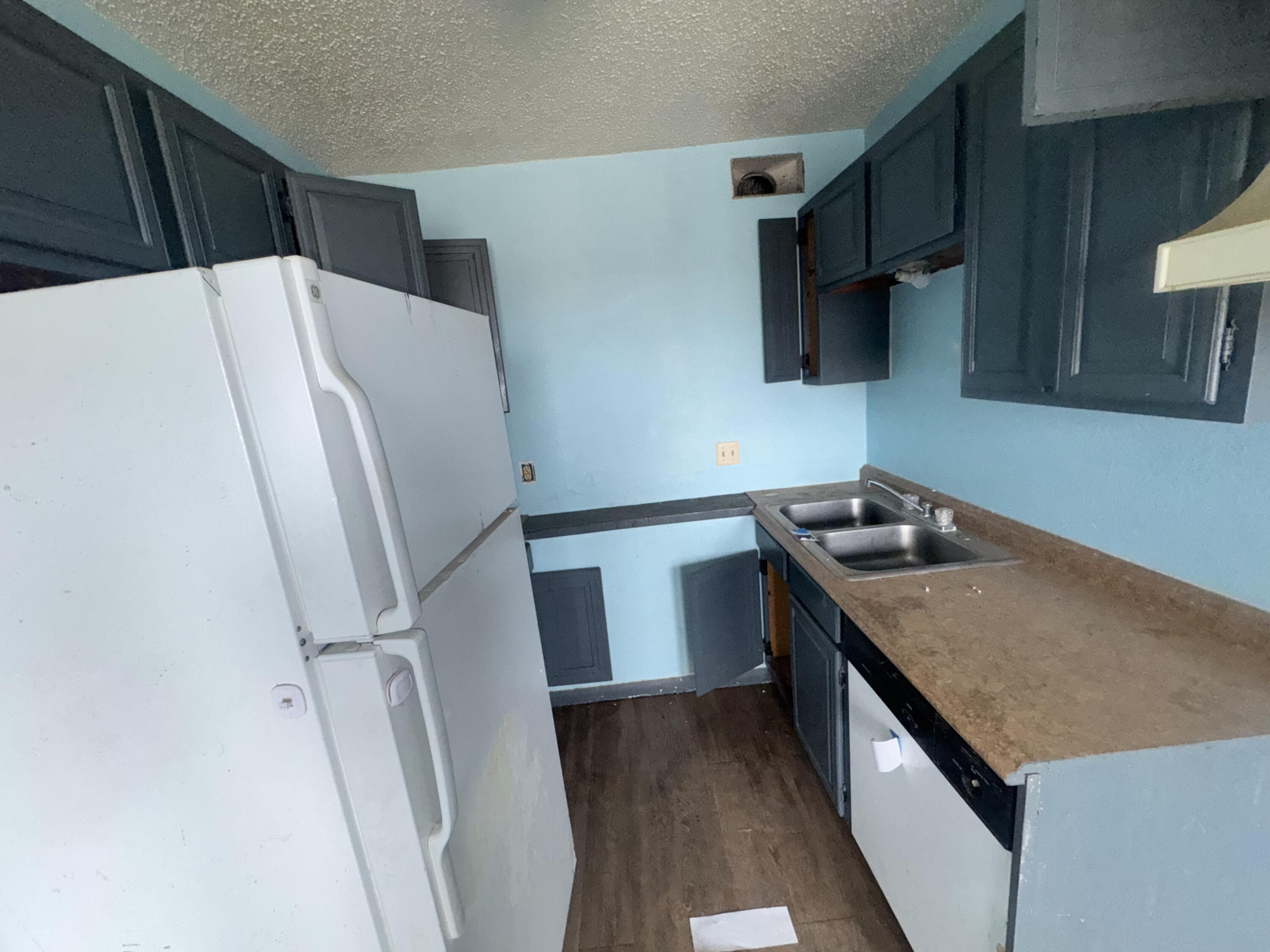 105 Pecos Place Plainview, TX 79072 - Photo 13 of 14 a kitchen with a sink a refrigerator and a stove top oven
