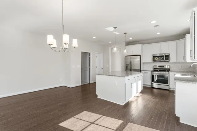 a large white kitchen with stainless steel appliances
