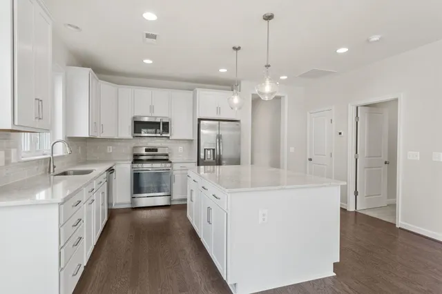 a kitchen with granite countertop white cabinets and a sink