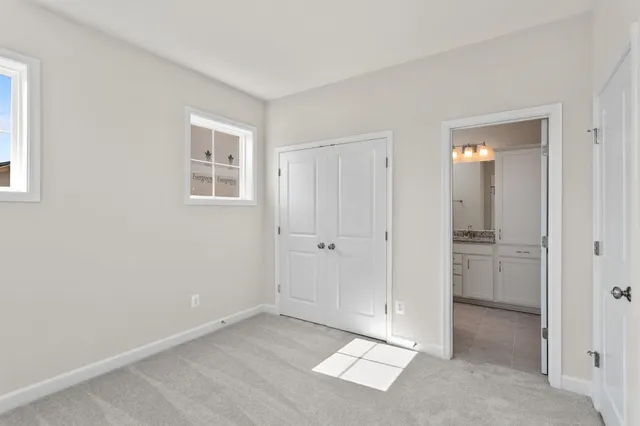 a view of an empty room with closet and a window