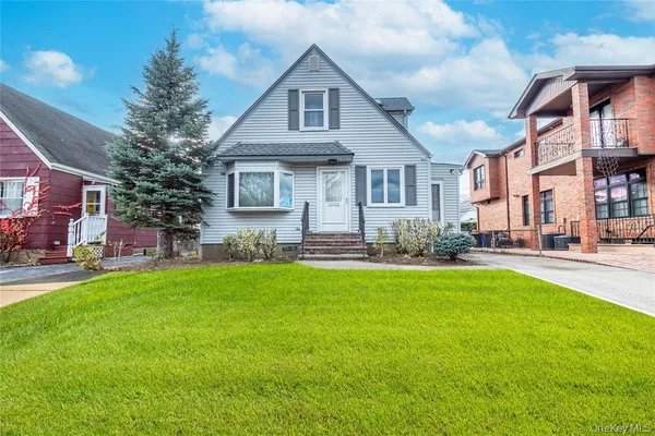 a front view of house with yard and outdoor seating