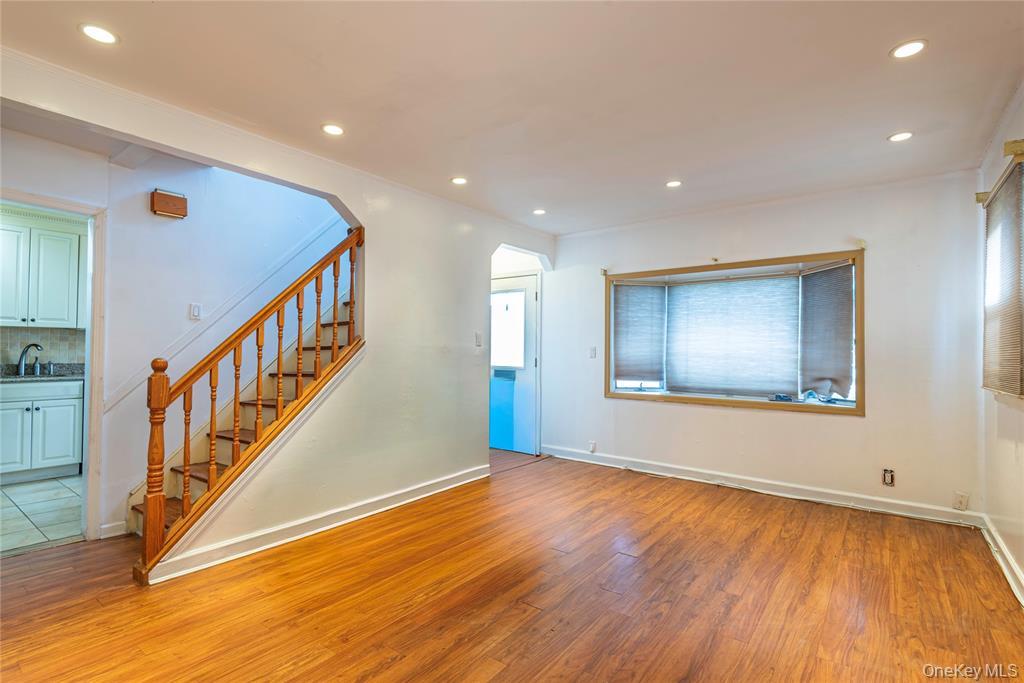 78-36 271st Street Queens, NY 11040 - Photo 3 of 17 a view of an empty room with wooden floor and stairs