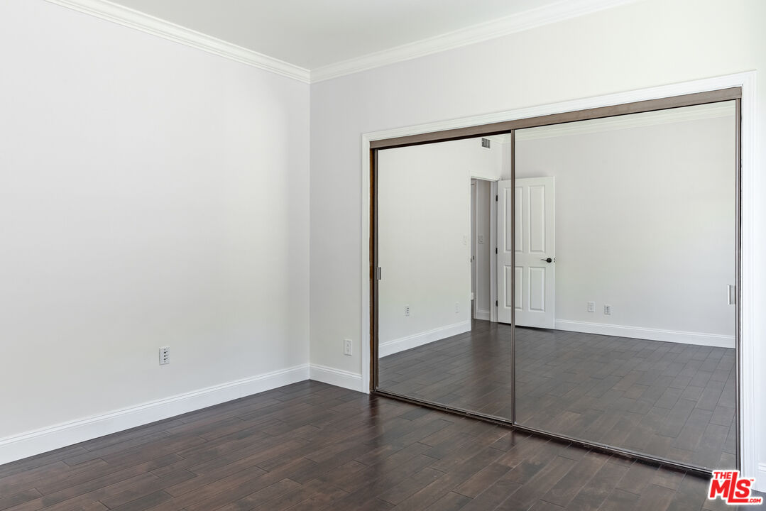 818 6th Street, Unit 102 Santa Monica, CA 90403 - Photo 15 of 29 an empty room with wooden floor and mirror