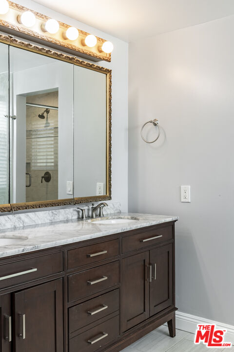 818 6th Street, Unit 102 Santa Monica, CA 90403 - Photo 21 of 29 a bathroom with a granite countertop sink and a mirror