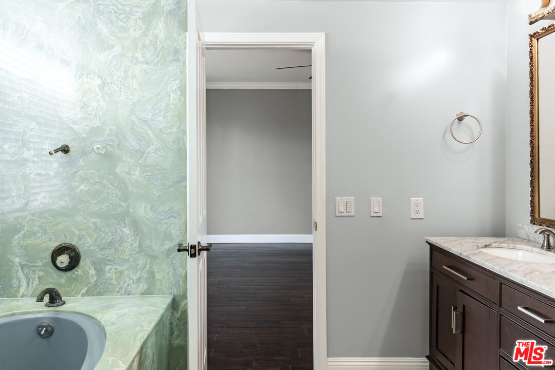 818 6th Street, Unit 102 Santa Monica, CA 90403 - Photo 22 of 29 a bathroom with a tub sink vanity granite and mirror