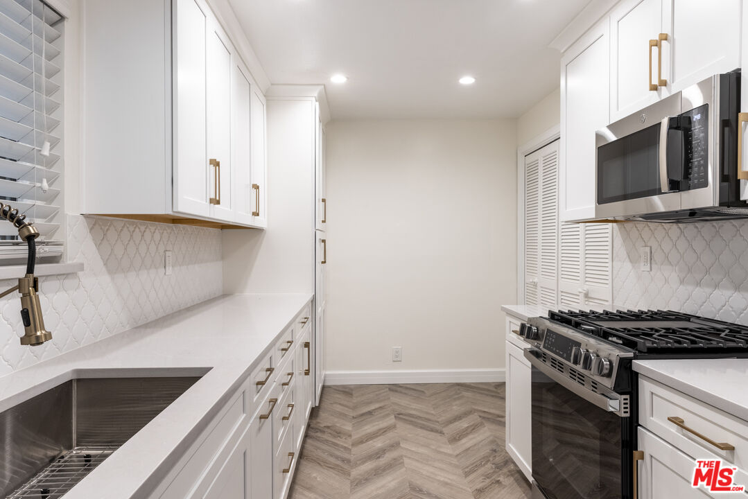 818 6th Street, Unit 102 Santa Monica, CA 90403 - Photo 3 of 29 a kitchen with stainless steel appliances granite countertop a stove and a microwave