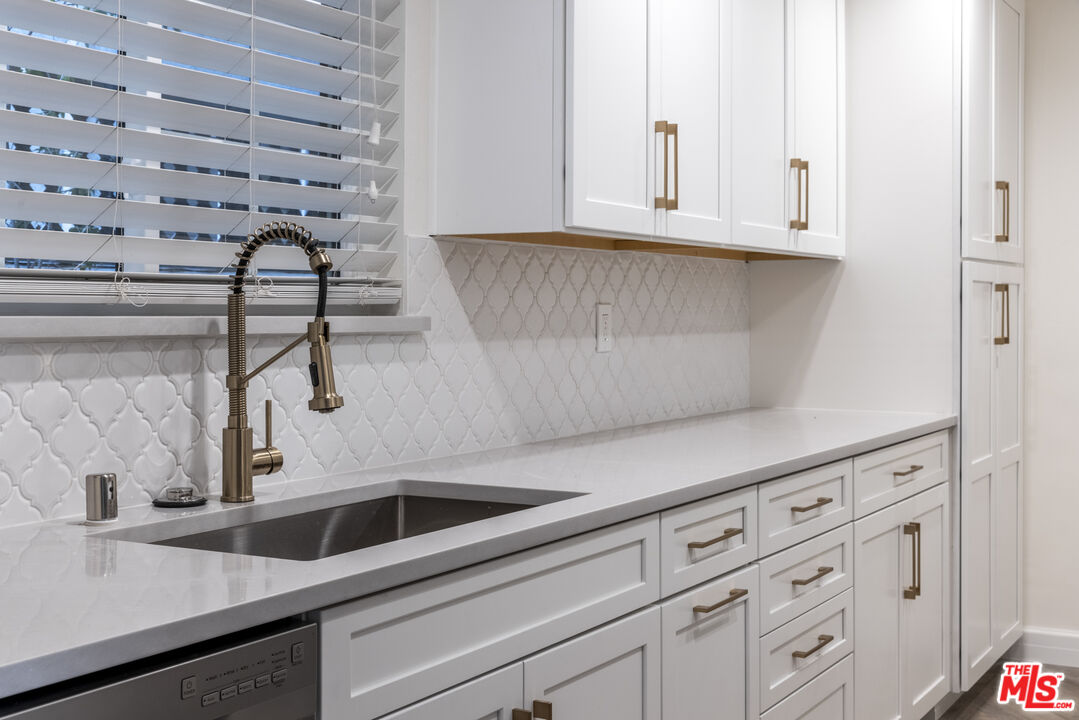 818 6th Street, Unit 102 Santa Monica, CA 90403 - Photo 4 of 29 a kitchen with granite countertop white cabinets and sink