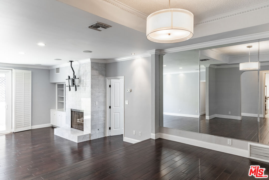 818 6th Street, Unit 102 Santa Monica, CA 90403 - Photo 7 of 29 an empty room with wooden floor and mirror