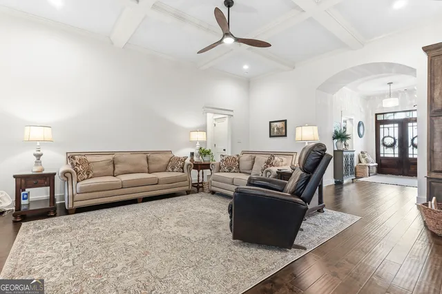 a kitchen with stainless steel appliances granite countertop a stove top oven a sink dishwasher and white cabinets with wooden floor