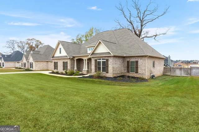 a view of a yard in front of a house with a large tree