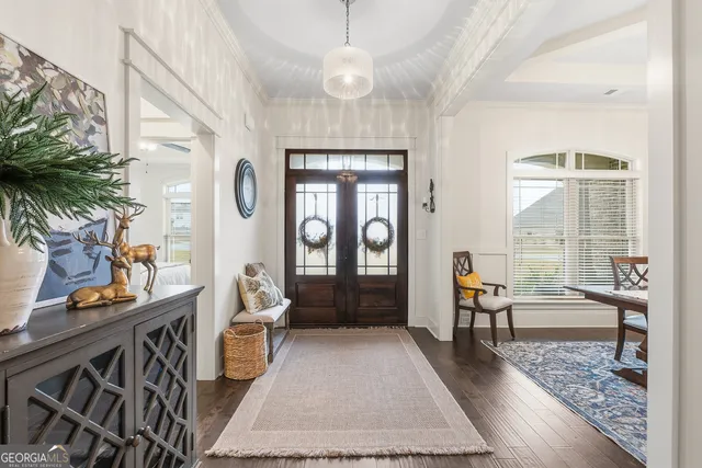a dining room with wooden floor a chandelier a wooden table and chairs
