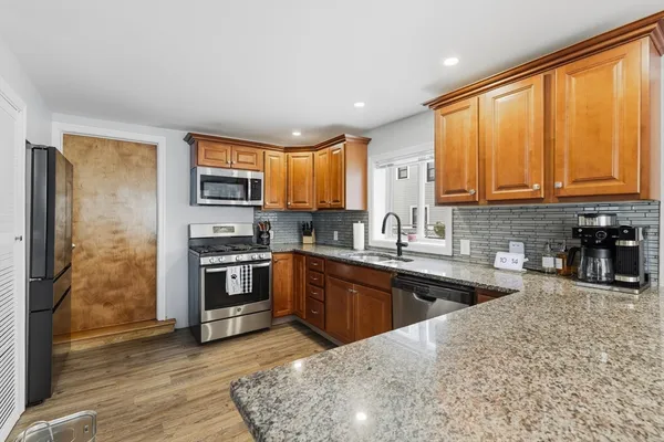 a kitchen with stainless steel appliances granite countertop a stove a sink and a microwave
