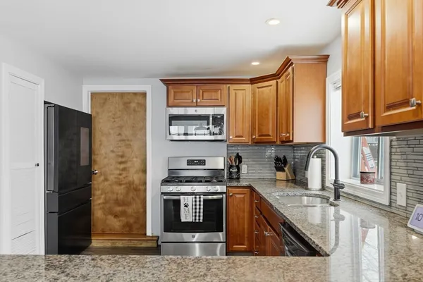 a kitchen with stainless steel appliances granite countertop a stove a sink and a microwave