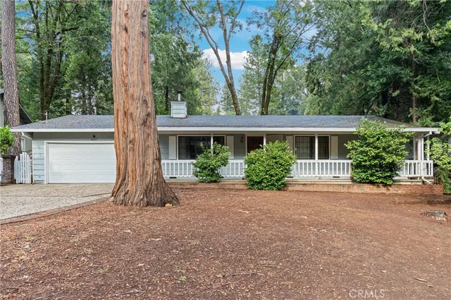 front view of a house with a yard and an trees