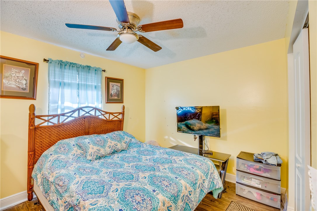 474 Azine Terrace Sebastian, FL 32958 - Photo 16 of 33 a bedroom with a bed and a lamp on dresser