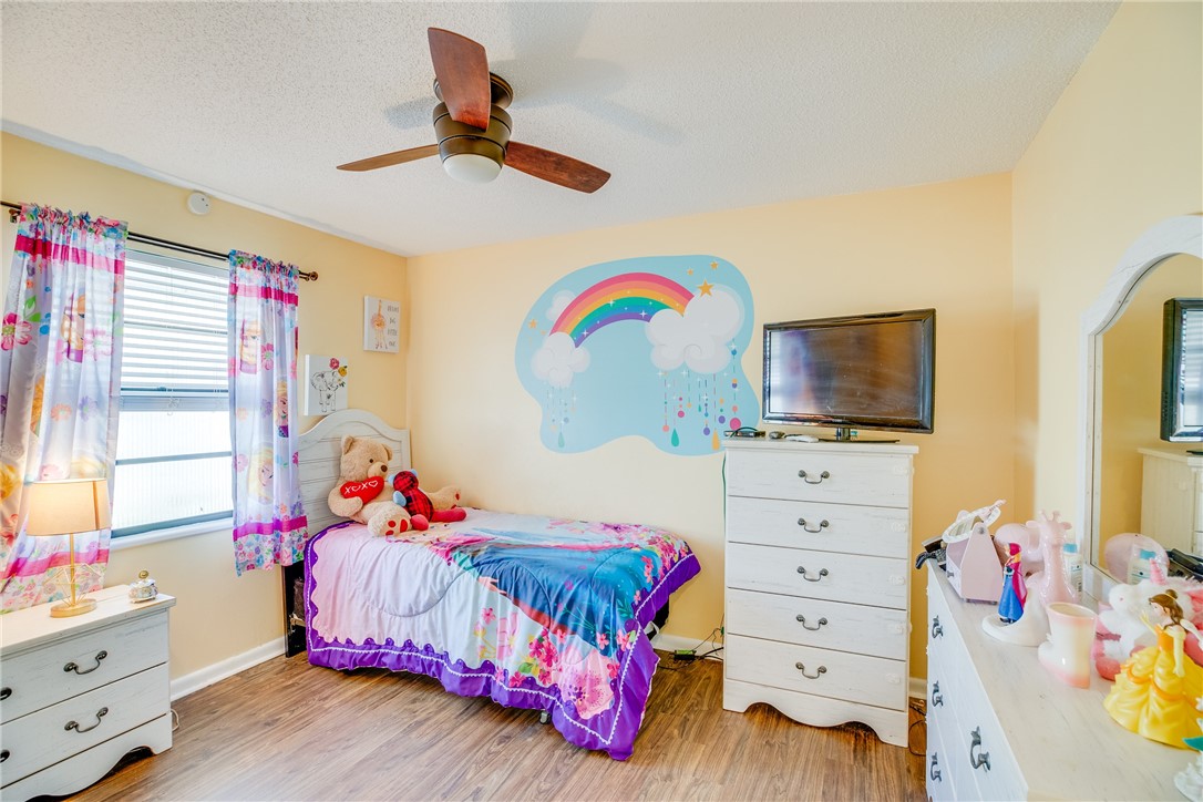 474 Azine Terrace Sebastian, FL 32958 - Photo 17 of 33 a bedroom with a bed and wooden floor