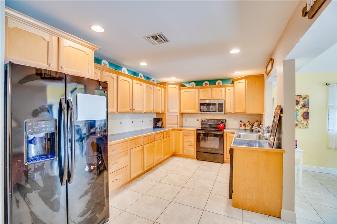 474 Azine Terrace Sebastian, FL 32958 - Photo 8 of 33 a kitchen with a refrigerator and a sink