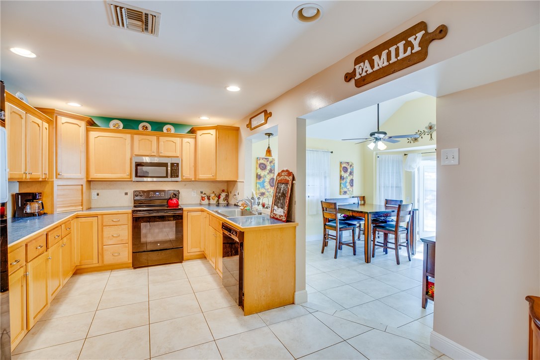 474 Azine Terrace Sebastian, FL 32958 - Photo 9 of 33 a kitchen with a stove a refrigerator and a dining table