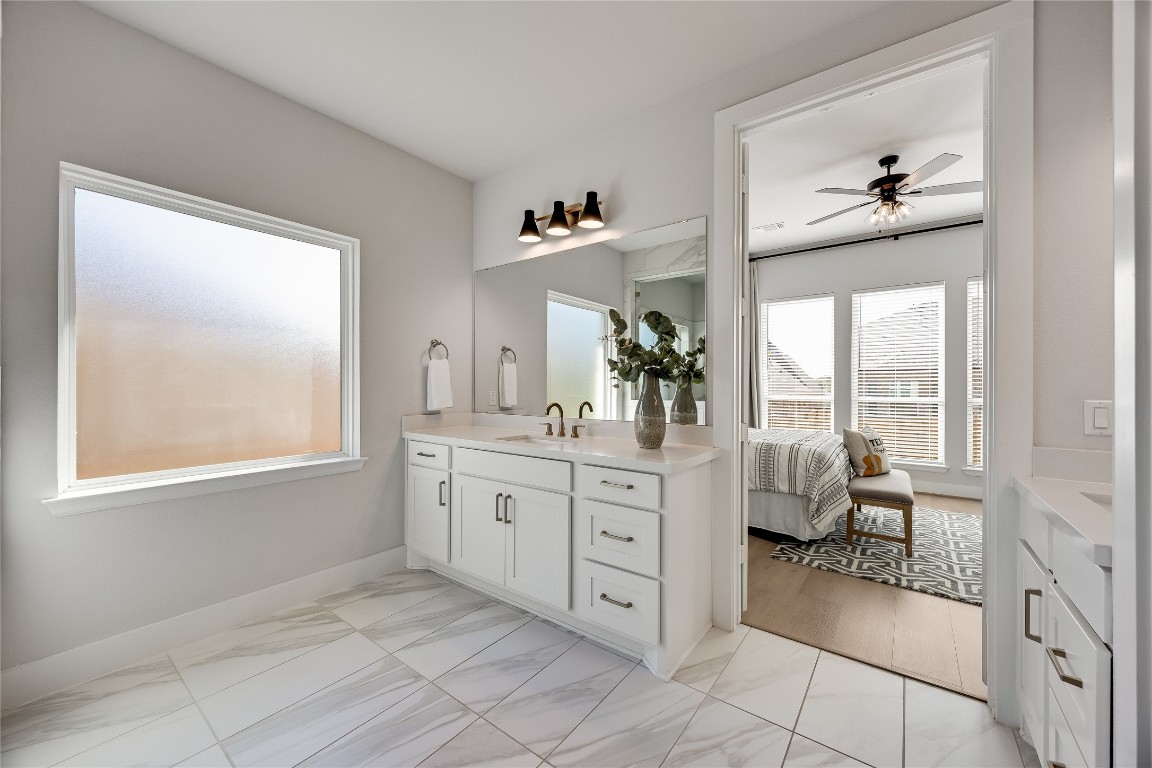 200 Grn Knl Lane Georgetown, TX 78628 - Photo 16 of 32 a spacious en suite bathroom with a double vanity sink a two mirror a window and a bathtub