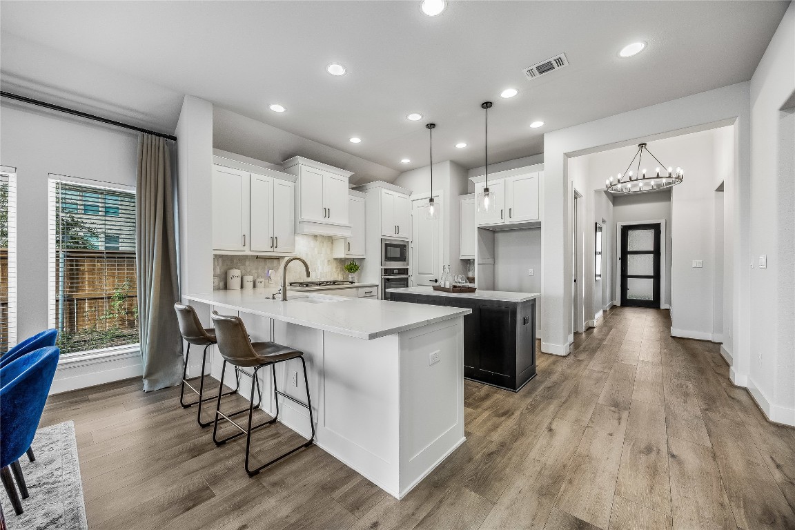200 Grn Knl Lane Georgetown, TX 78628 - Photo 6 of 32 a kitchen with stainless steel appliances kitchen island granite countertop a table chairs sink and cabinets