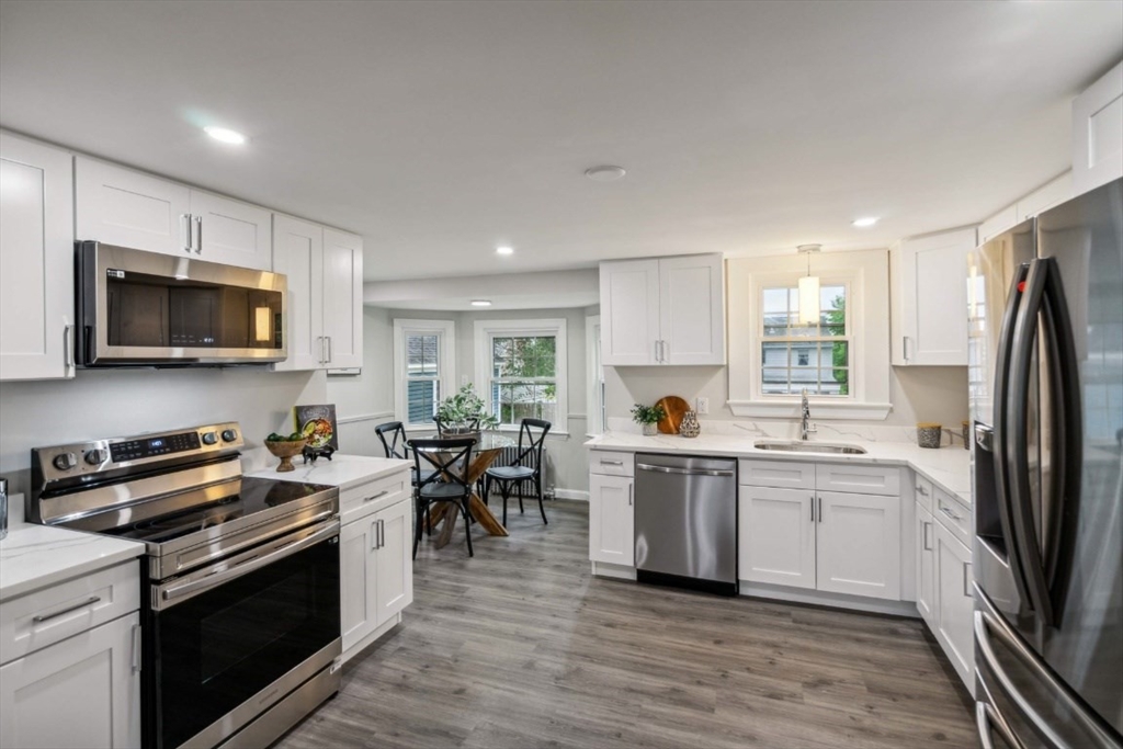 1 Arbor Road North Chelmsford, MA 01863 - Photo 2 of 40 a kitchen with stainless steel appliances a stove top oven a sink dishwasher a refrigerator white cabinets and wooden floor