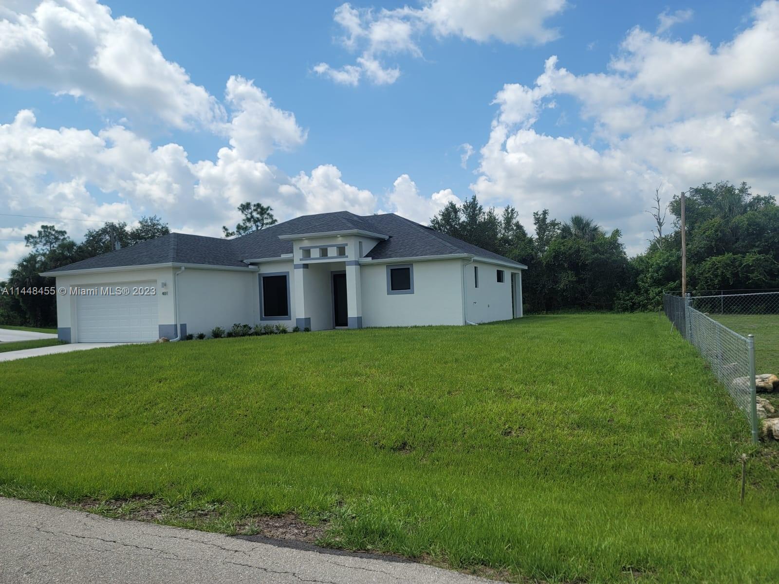 401 West 5th Street, Unit ST Lehigh Acres, FL 33972 - Photo 2 of 10 a front view of a house with garden