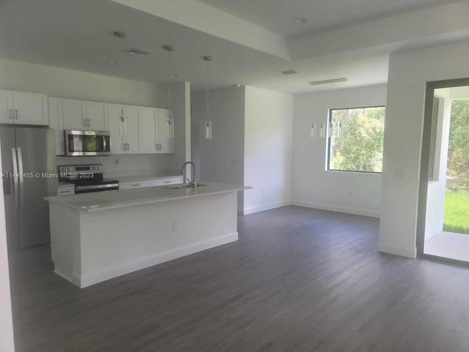 401 West 5th Street, Unit ST Lehigh Acres, FL 33972 - Photo 5 of 10 a kitchen with stainless steel appliances a refrigerator and a stove top oven