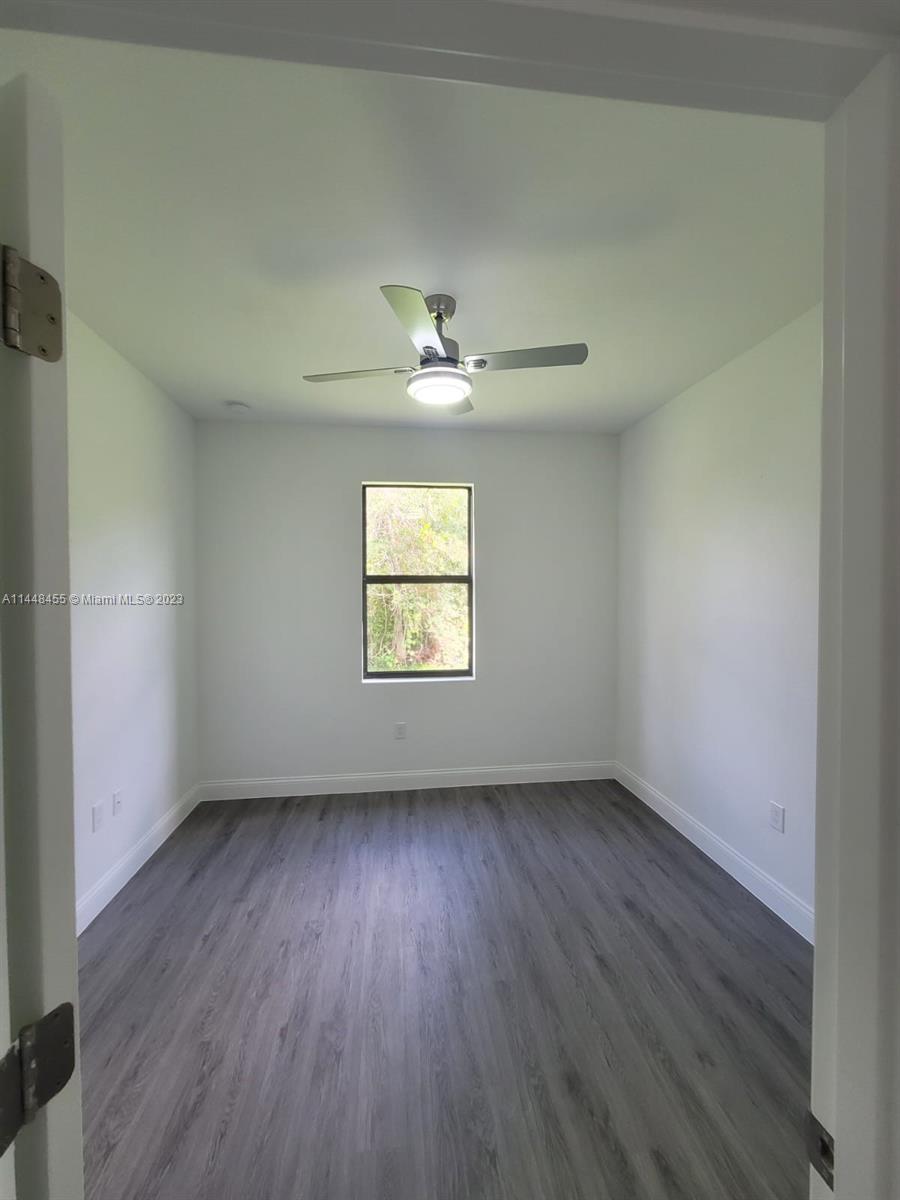 401 West 5th Street, Unit ST Lehigh Acres, FL 33972 - Photo 8 of 10 an empty room with a window and a ceiling fan