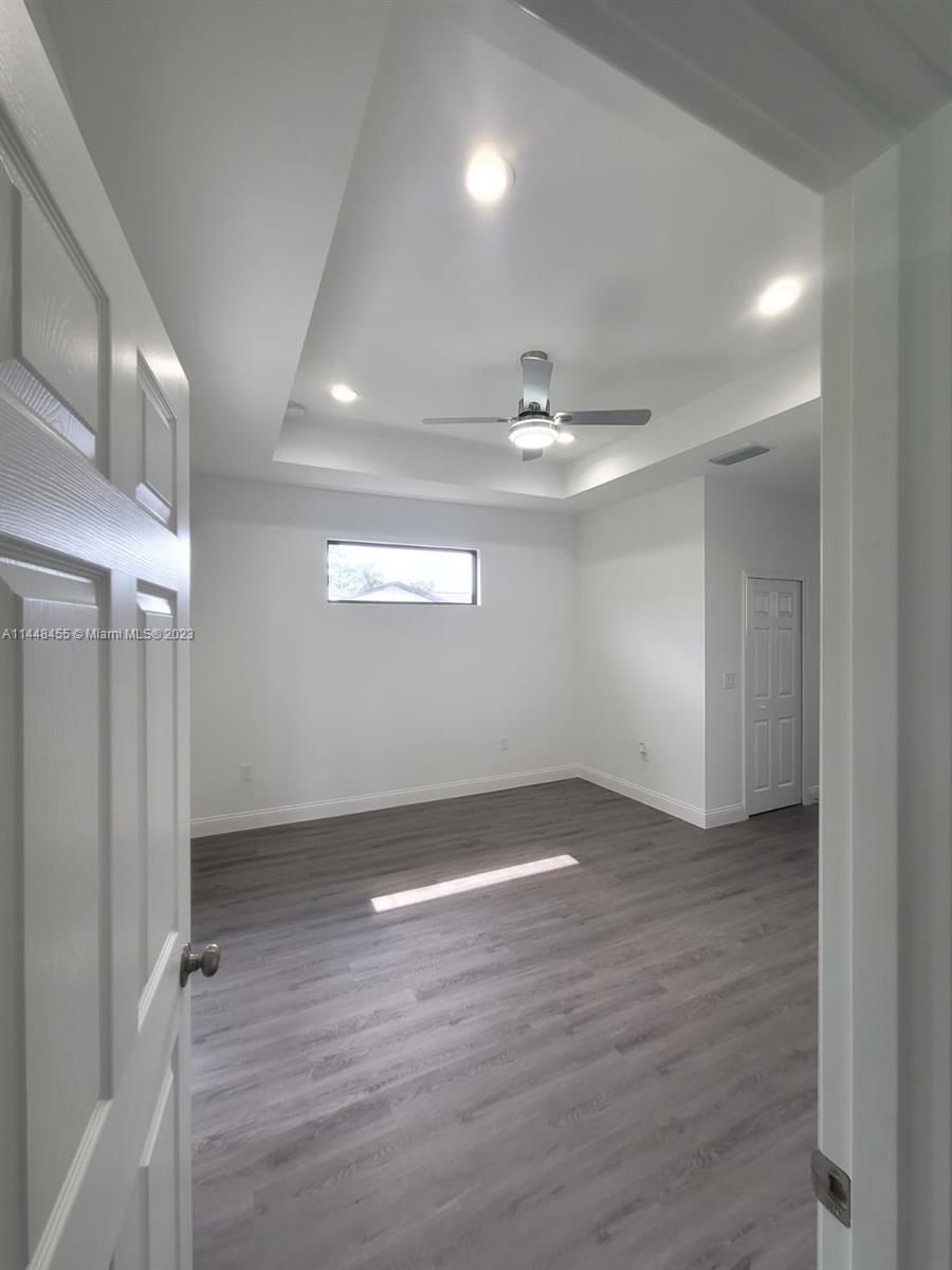 401 West 5th Street, Unit ST Lehigh Acres, FL 33972 - Photo 9 of 10 an empty room with wooden floor and windows