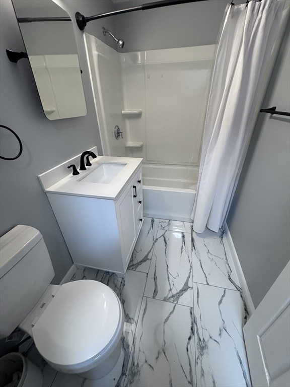 27 Gordon Street, Unit 108 Framingham, MA 01702 - Photo 11 of 11 a bathroom with a sink mirror vanity and toilet