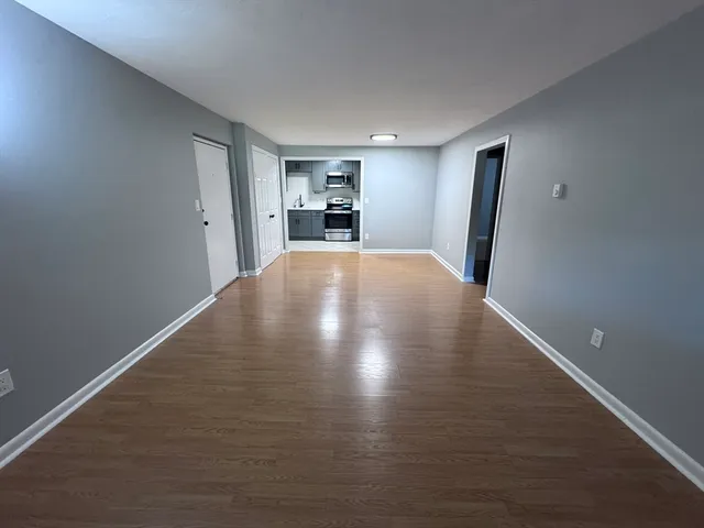 a view of empty room with wooden floor