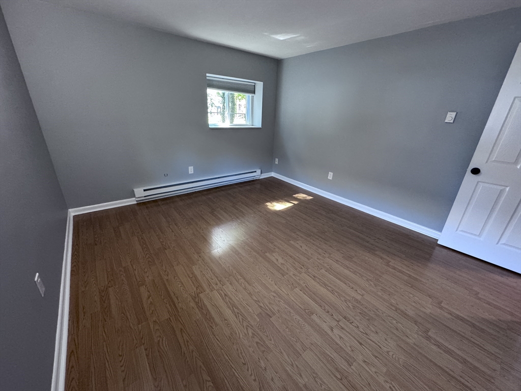 27 Gordon Street, Unit 108 Framingham, MA 01702 - Photo 6 of 11 wooden floor in an empty room with a window
