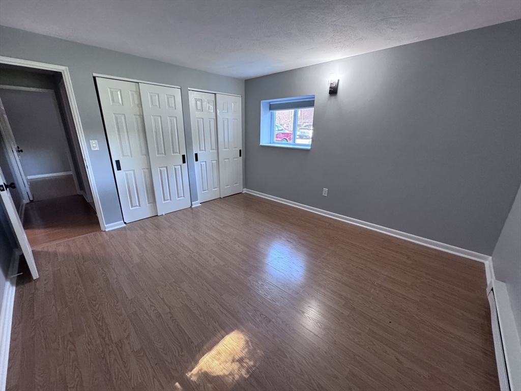 27 Gordon Street, Unit 108 Framingham, MA 01702 - Photo 7 of 11 a view of an empty room with wooden floor and a window