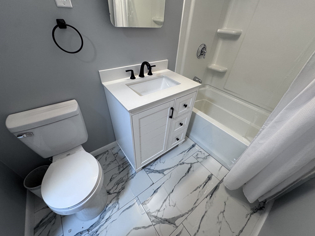 27 Gordon Street, Unit 108 Framingham, MA 01702 - Photo 10 of 11 a bathroom with a toilet sink and mirror