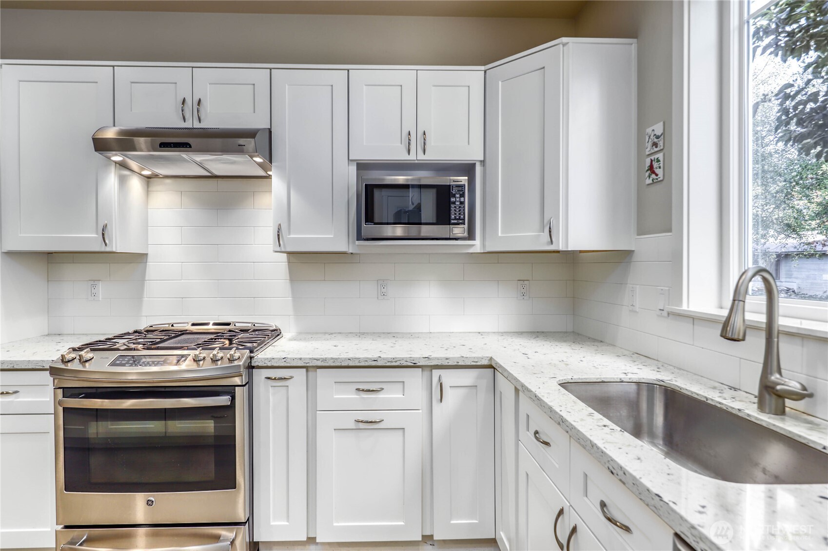 690 Wintersweet Road Northeast Bainbridge Island, WA 98110 - Photo 14 of 23 a kitchen with granite countertop white cabinets and stainless steel appliances