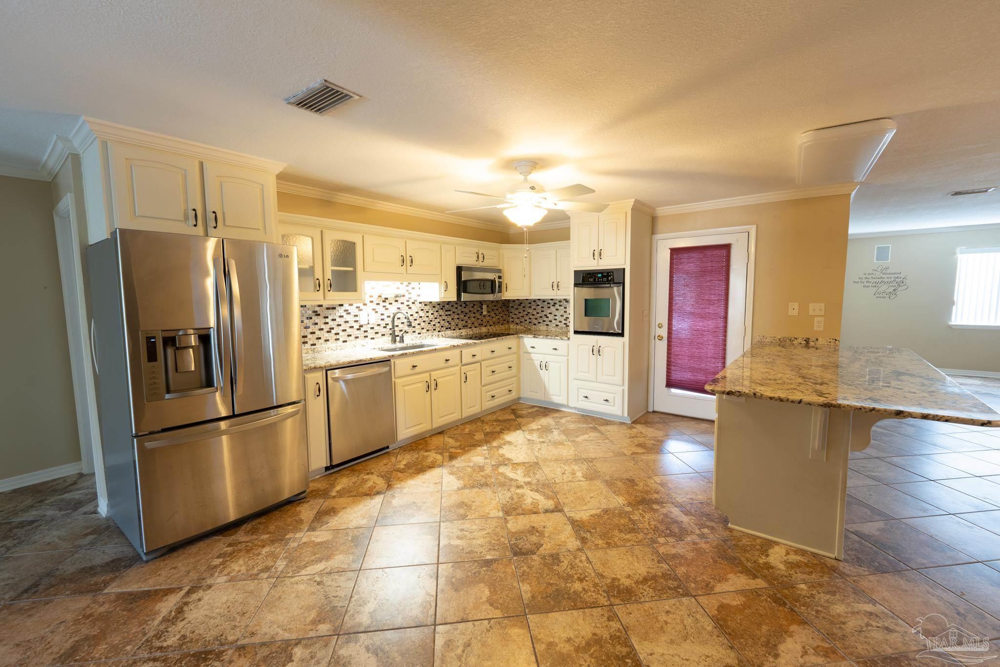 7608 River Road Milton, FL 32583 - Photo 13 of 28 a kitchen with stainless steel appliances granite countertop a refrigerator and a sink