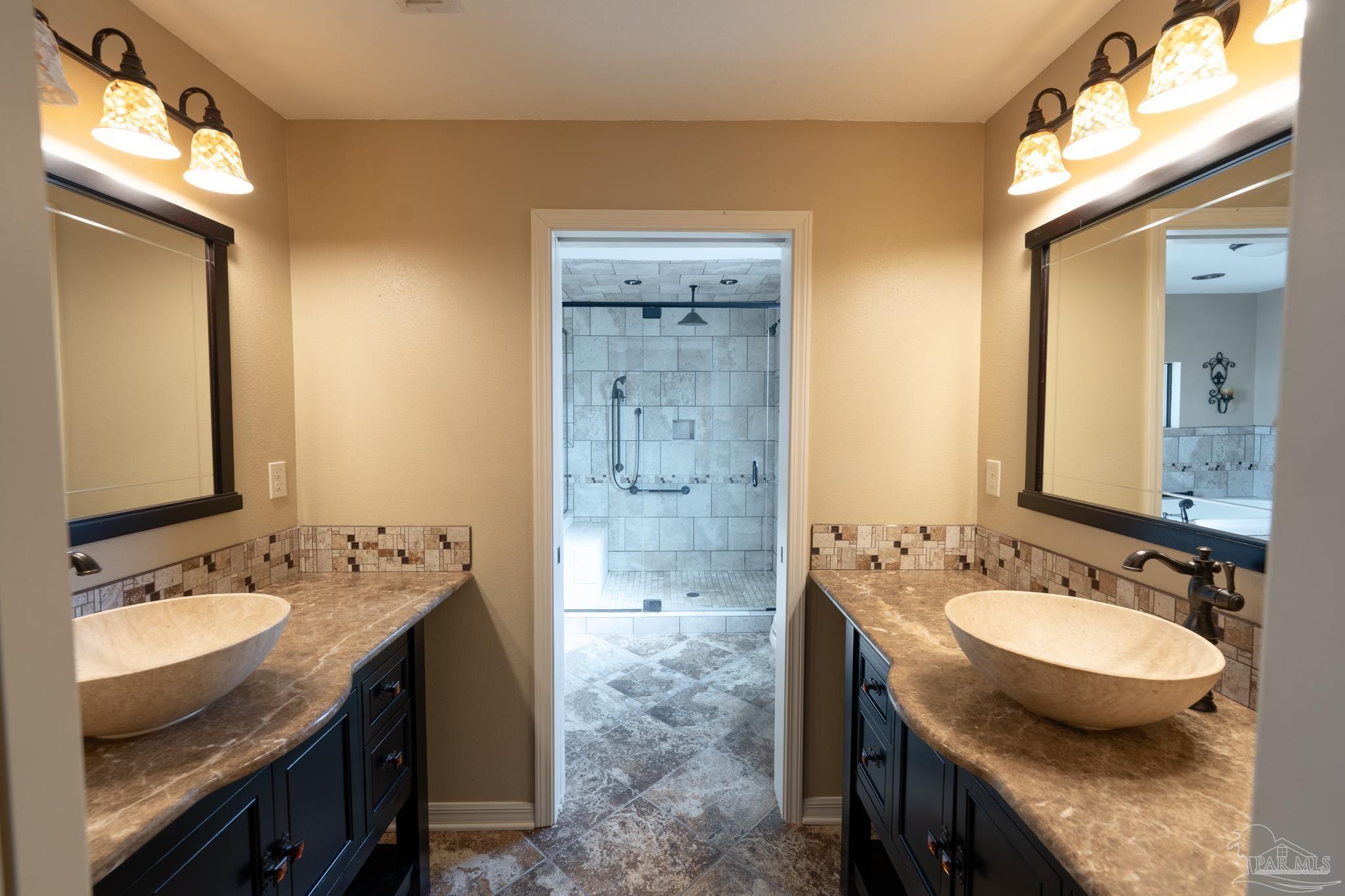 7608 River Road Milton, FL 32583 - Photo 16 of 28 a bathroom with a granite countertop sink a toilet a mirror and shower