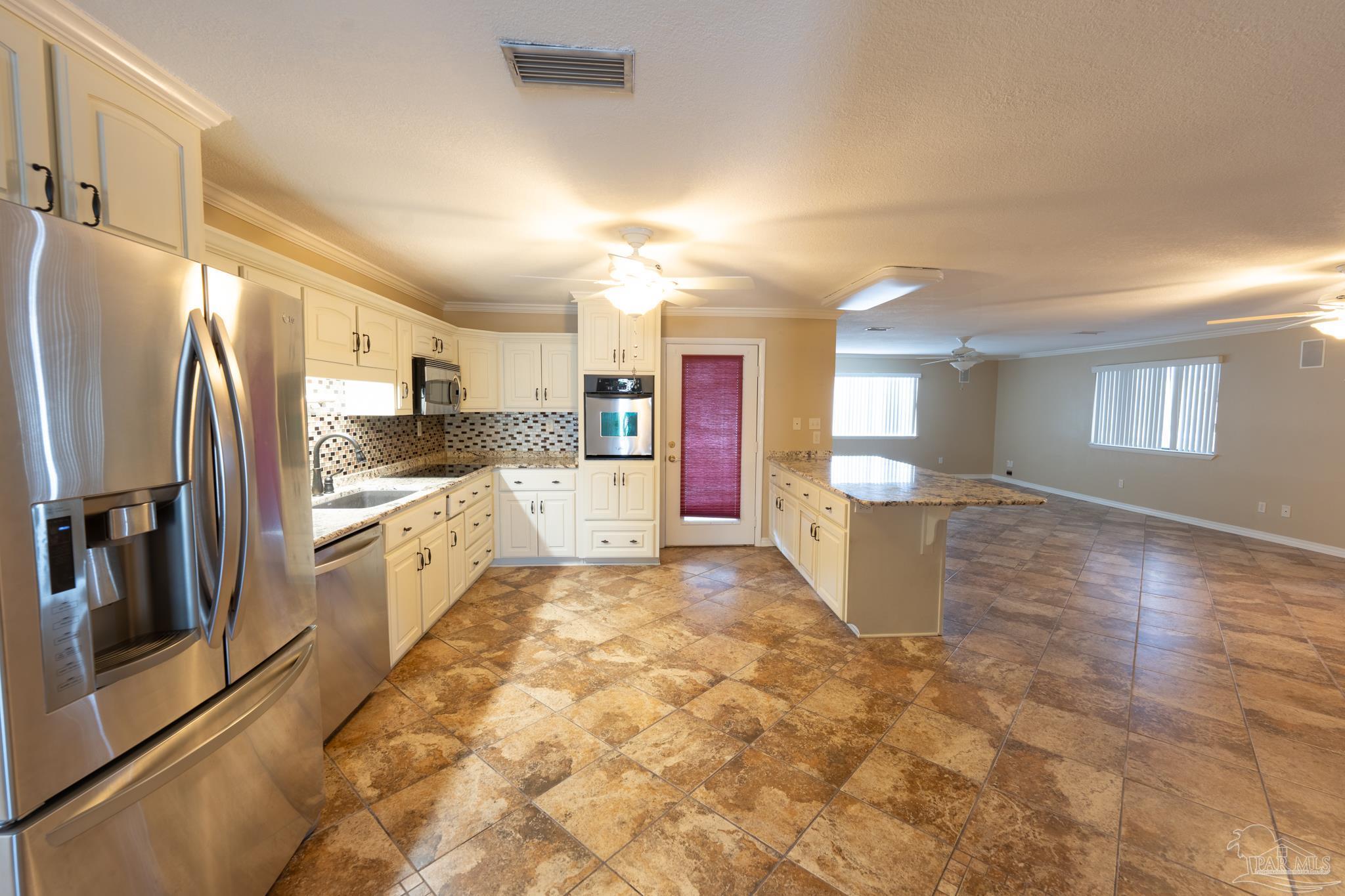7608 River Road Milton, FL 32583 - Photo 17 of 28 a large kitchen with cabinets and stainless steel appliances