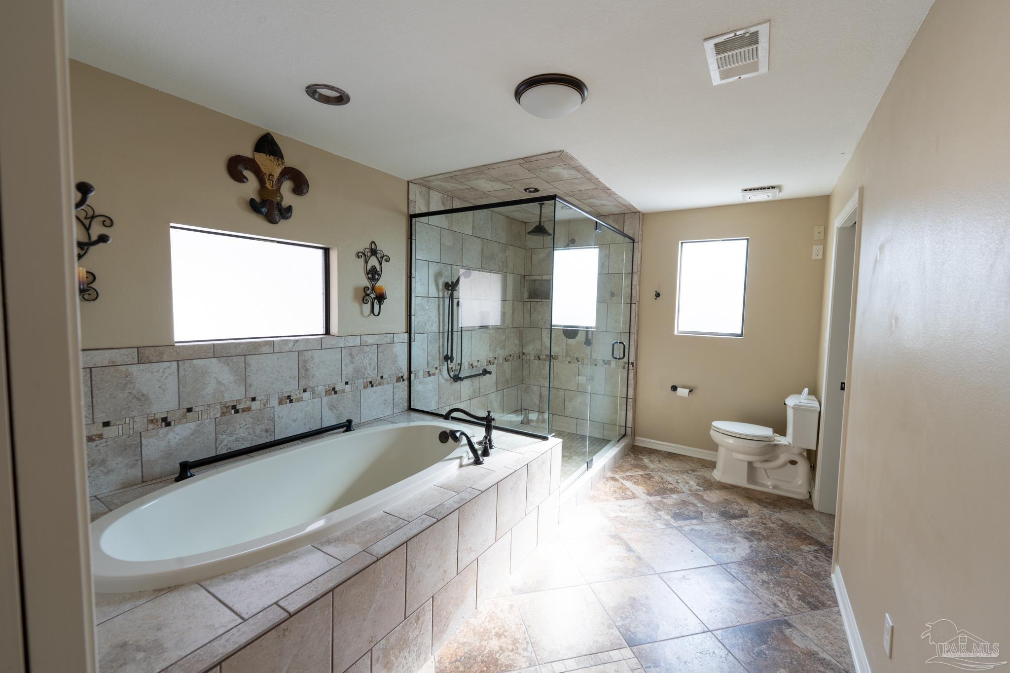 7608 River Road Milton, FL 32583 - Photo 18 of 28 a spacious bathroom with a granite countertop sink a toilet and shower