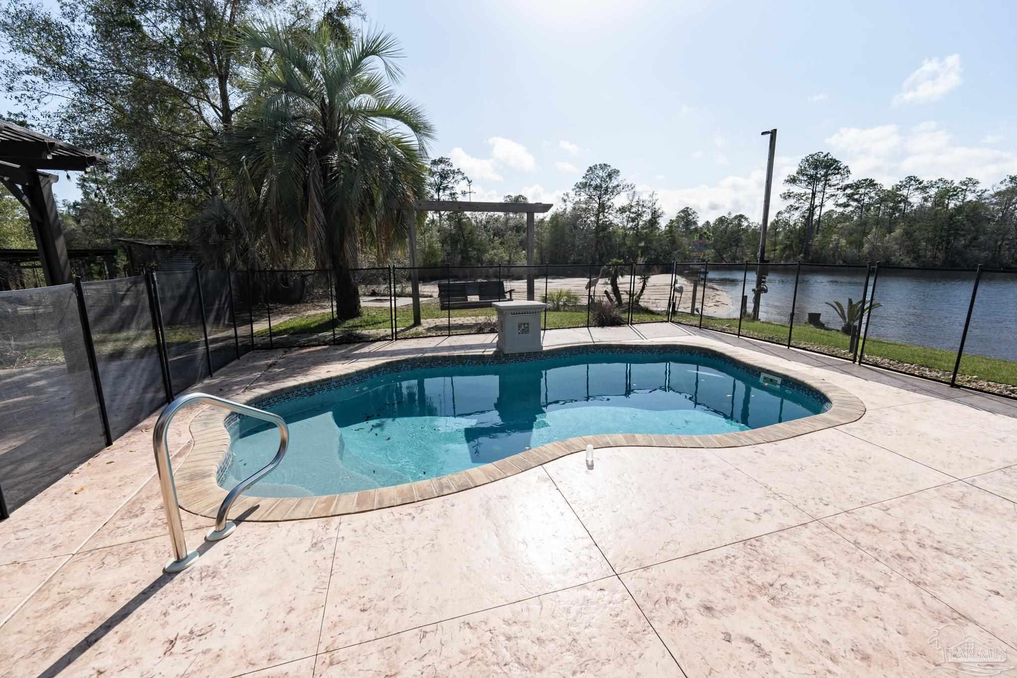 7608 River Road Milton, FL 32583 - Photo 20 of 28 a view of a swimming pool with a lounge chair