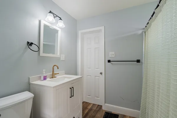 a bathroom with a toilet a sink and mirror