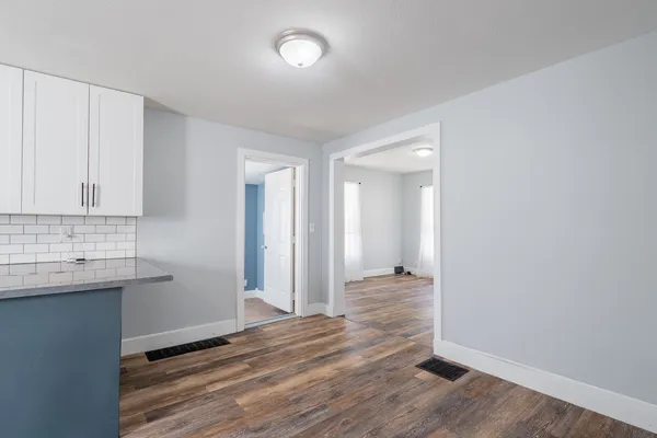 an empty room with wooden floor and mirror