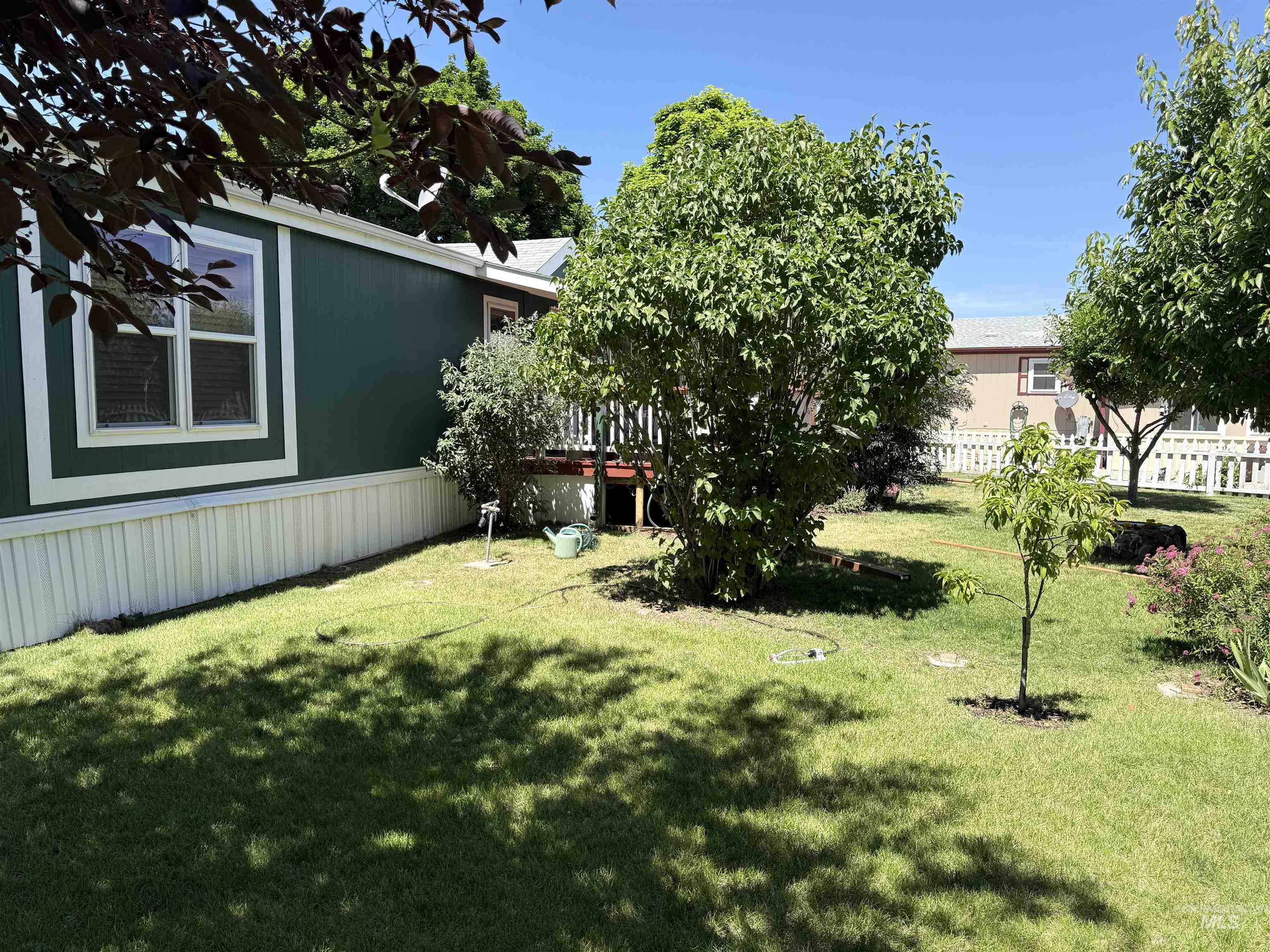 2750 Alden Road, Unit 12 12 Fruitland, ID 83619 - Photo 33 of 38 Expansive green lawn with mature trees and a stone-lined fire pit
