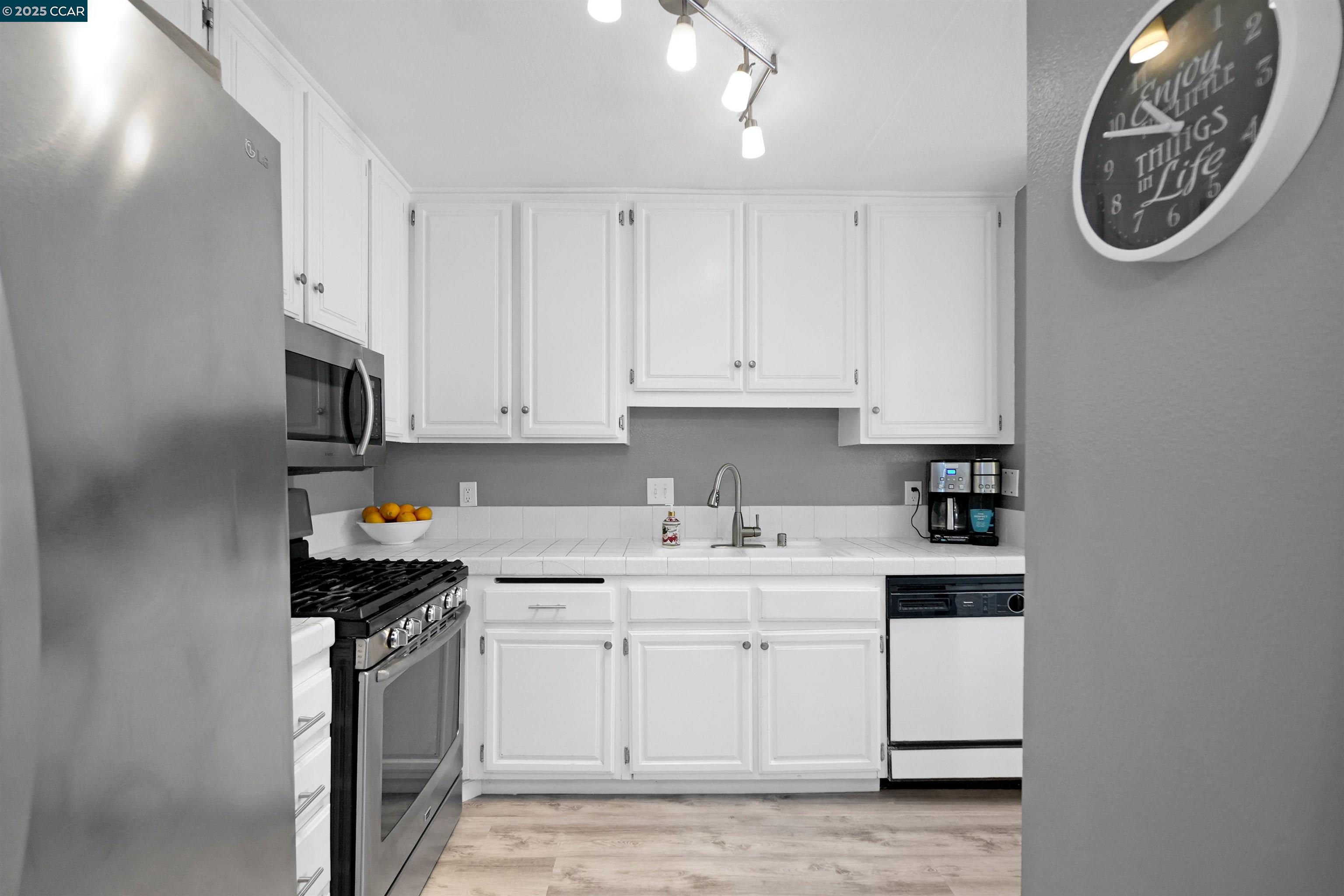 303 Atlas Drive, Unit 7 Hercules, CA 94547 - Photo 19 of 52 a kitchen with stainless steel appliances granite countertop a sink a stove a microwave and cabinets