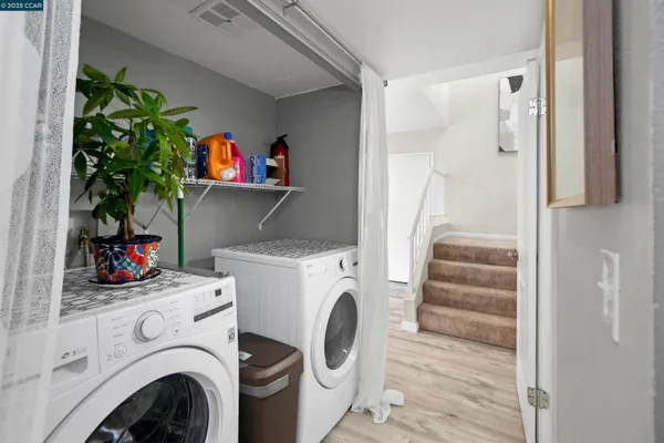 a utility room with dryer washer and a view of bedroom